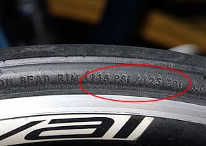 You can find the correct pressure printed or molded onto the wall of the tire - this one reads 115PSI/125PSI